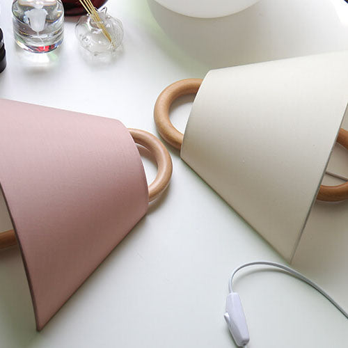 Fabric wall sconce lit to show the glow through the pleats