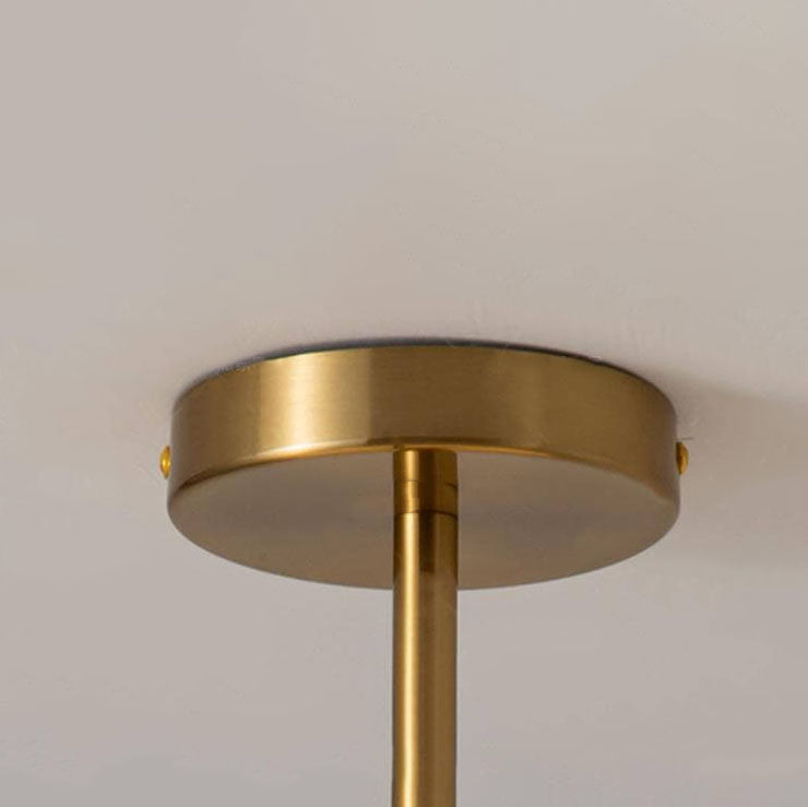 Amber glass ceiling light lit warmly against a neutral wall