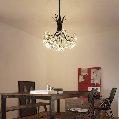 Black glass chandelier lighting a wooden dining table with red wall art