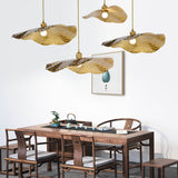Hammered gold leaf pendant lights over a walnut tea table setting