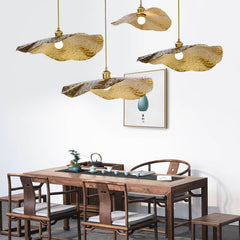 Hammered gold leaf pendant lights over a walnut tea table setting