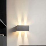 Grey aluminum wall sconce with up and down beams by a staircase