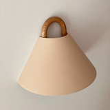 Fabric wall sconce shown unlit on a plain wall
