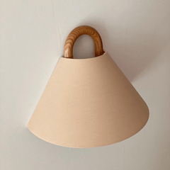 Fabric wall sconce shown unlit on a plain wall