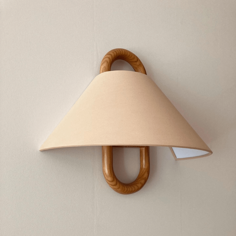 Fabric wall sconce lit warmly in a studio setting