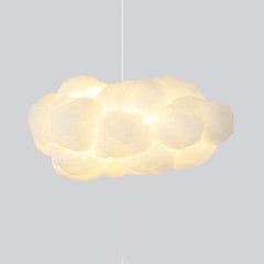 Cloud pendant light casting a warm ambient glow on a grey backdrop