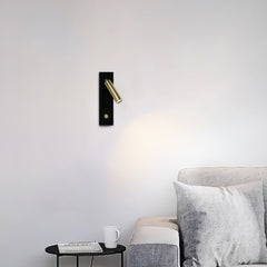 Nickel finish reading wall sconce mounted beside a headboard