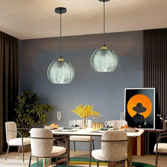 Green glass palm leaf pendant as decorative lighting over a styled dining room table