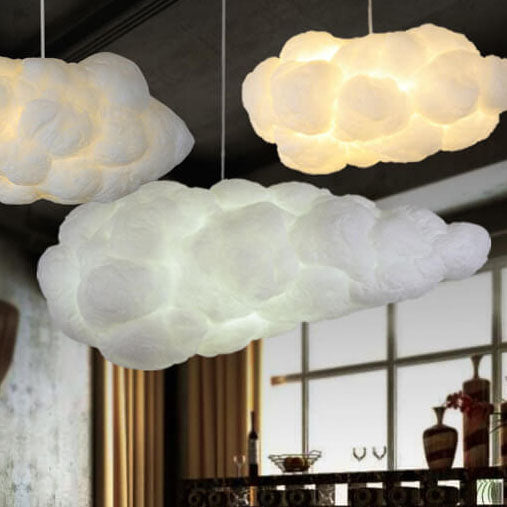 Three white cloud pendant lights above a table in an industrial dining room