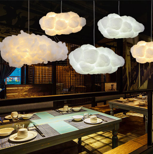 White cloud pendants lighting a dim restaurant with set dining tables