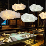 White cloud pendants lighting a dim restaurant with set dining tables