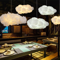 White cloud pendants lighting a dim restaurant with set dining tables