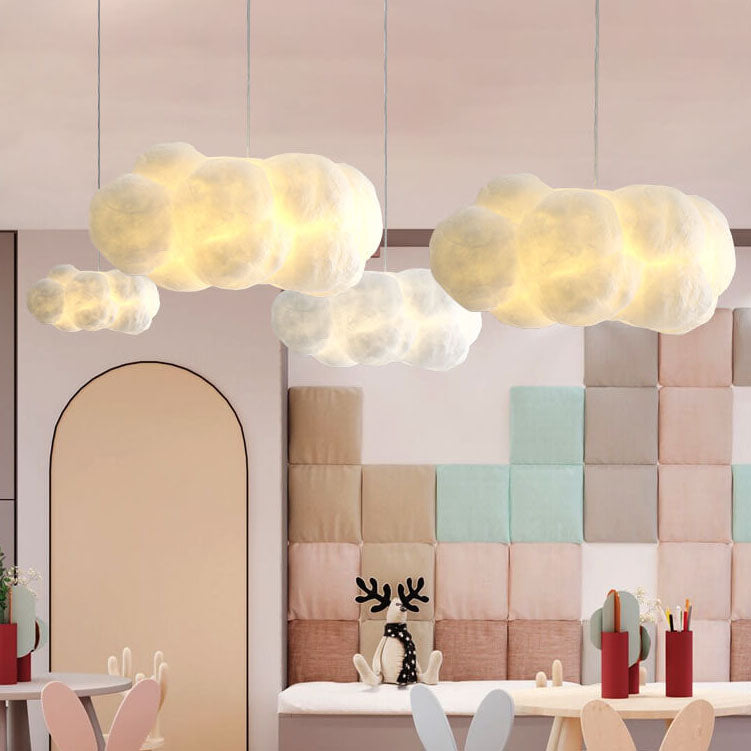 White cloud pendant lights glowing above a pastel padded children's playroom wall