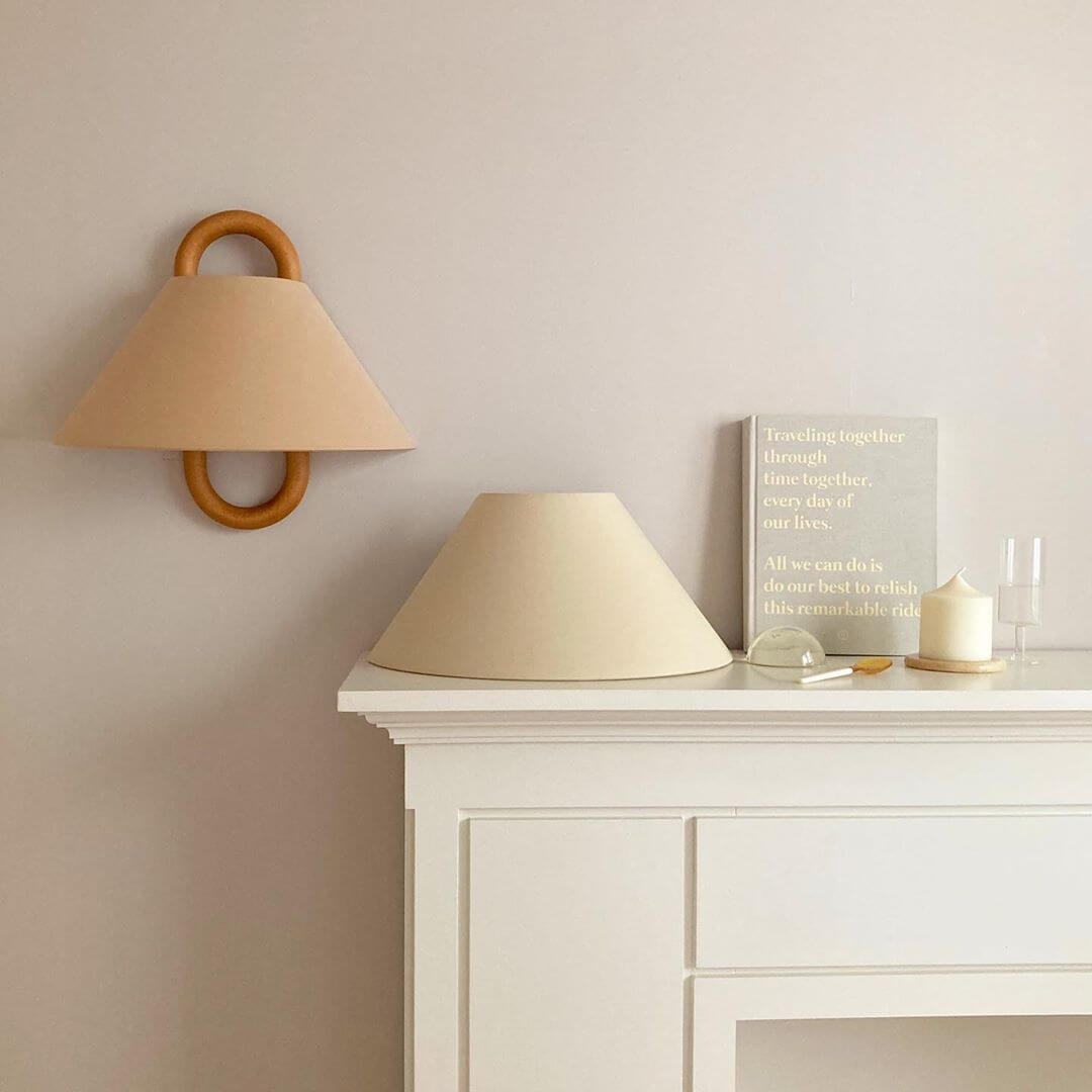 Pleated fabric wall sconce shown at an angle on the wall