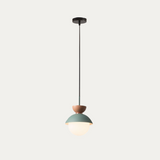 Pink macaron pendant light illuminated above a styled shelf