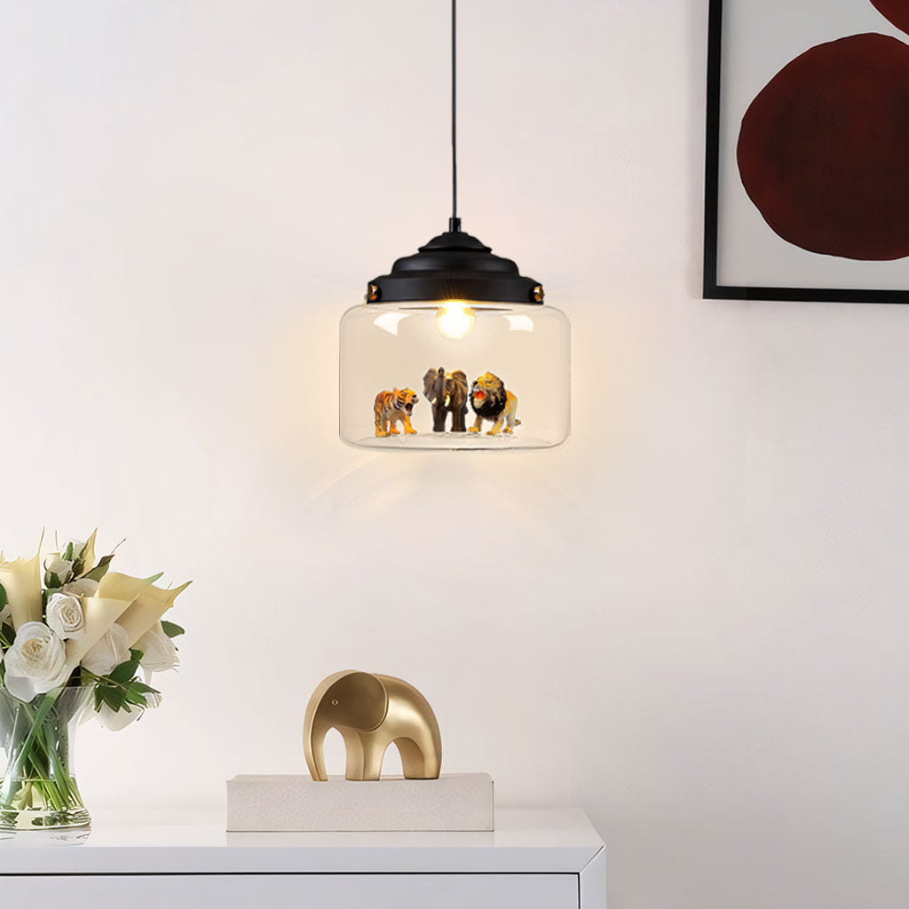Black-capped glass pendant lit above a sideboard, tiger, elephant and lion figures glowing inside