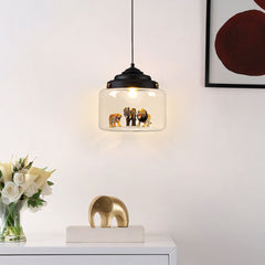 Black-capped glass pendant lit above a sideboard, tiger, elephant and lion figures glowing inside