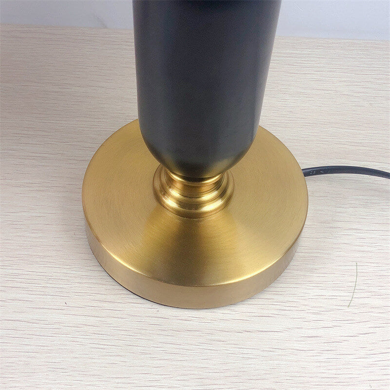 Detail of the round brass base and lower column of the lamp