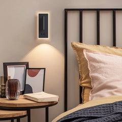 Compact wall mounted reading lamp for a bedside setting