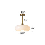 Amber glass flush mount ceiling light lit in a styled room setting