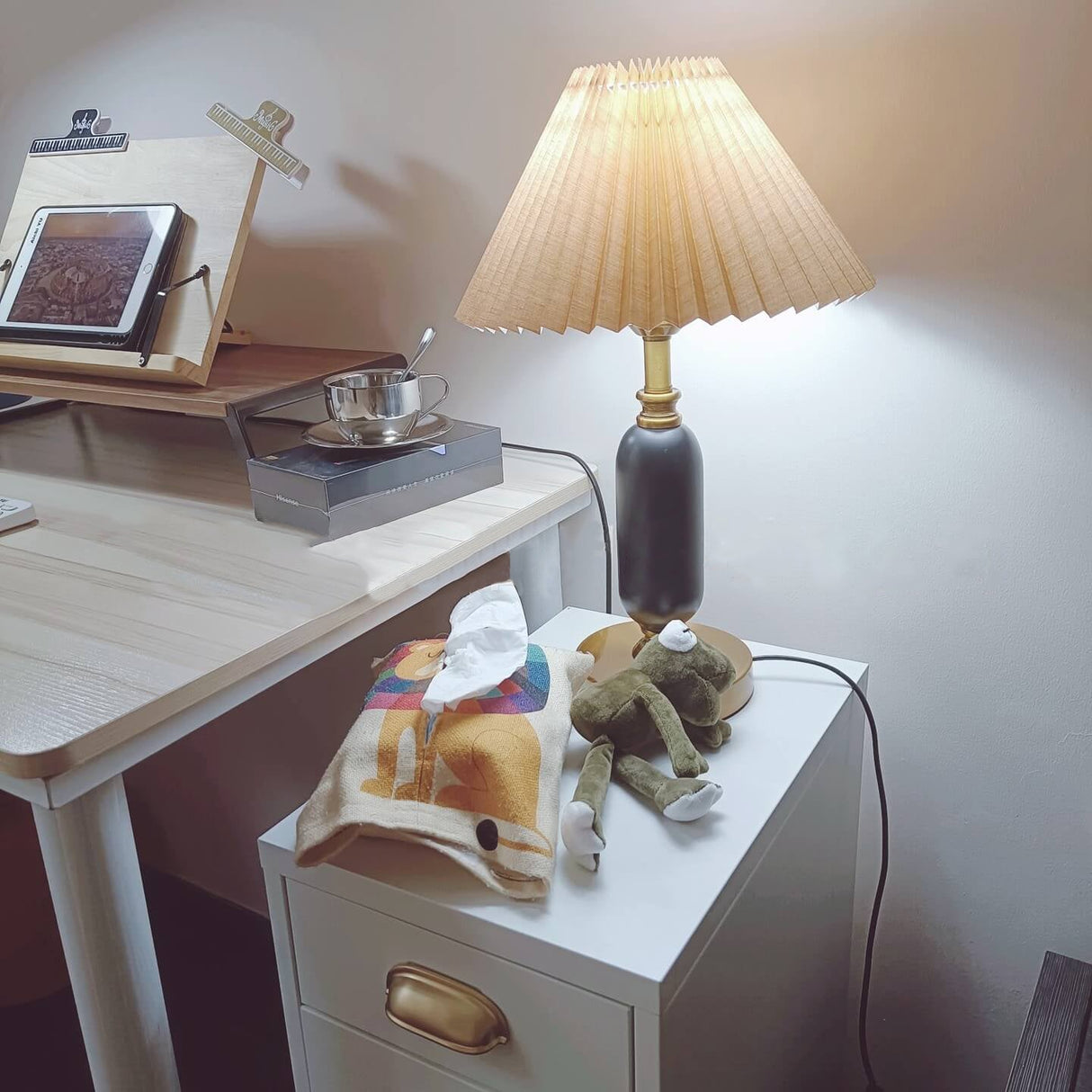 Pleated shade table lamp shown against a plain neutral backdrop
