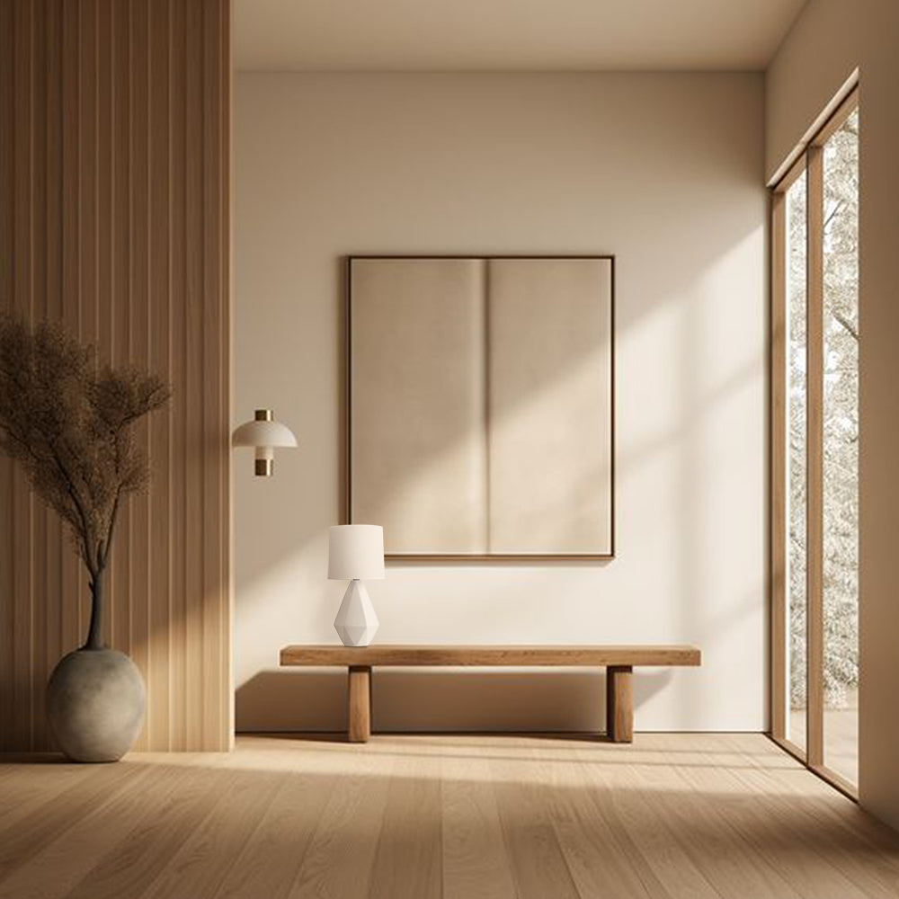 Small white ceramic table lamp on a wooden bench in a minimalist hallway