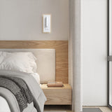 Modern bedside wall sconce mounted at shoulder height