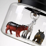 Close-up inside the glass shade showing hippo, zebra and rhino figures around a lit bulb