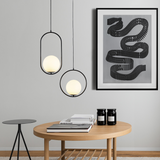 Two black frame glass globe pendants hung at different drops in a cream living room