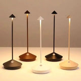 White rechargeable table lamp glowing warmly in a dim room