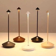 White rechargeable table lamp glowing warmly in a dim room