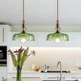 Antique brass and glass flower pendant light shown against a plain background