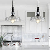 Clear glass flower pendant shade catching light along its ribbed edges