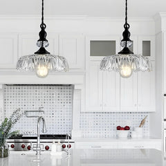 Clear glass flower pendant shade catching light along its ribbed edges