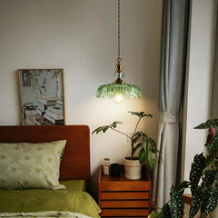 Close view of the petal-edged glass shade on the brass pendant light