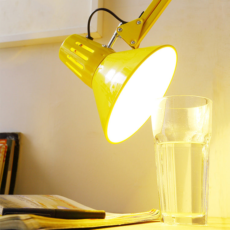 Yellow swing arm floor lamp standing upright on a studio floor