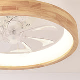 Angled shot of the round wood ceiling fan light against grey