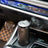 Black and silver diffuser in a car's cup holder with a blurred interior background