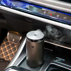 Black and silver diffuser in a car's cup holder with a blurred interior background