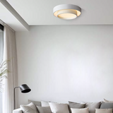 Disc ceiling light lit in a cool tone