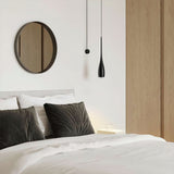 Water drop pendant light styled above a minimalist tabletop scene