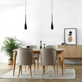 Water drop pendant light suspended above a modern dining setting