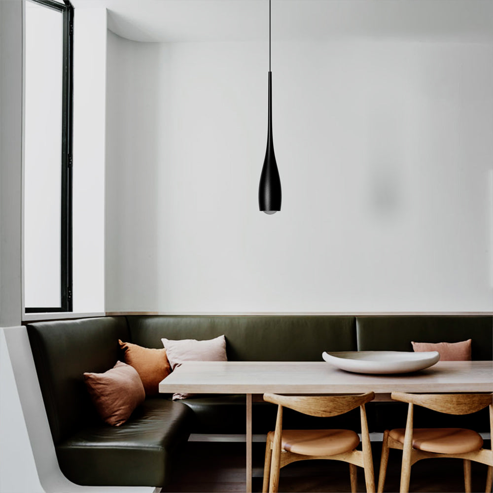 Minimalist pendant light adding warm glow to a dining area