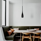 Minimalist pendant light adding warm glow to a dining area