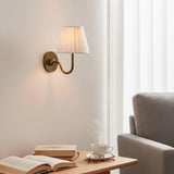 Detail of the round backplate and curved arm on the pleated fabric sconce, green shade side view 12