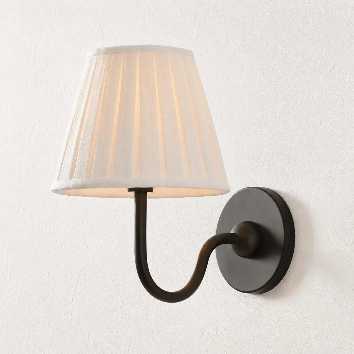 Pleated linen shade wall sconce shown against a plain studio background, sage green shade side view 32