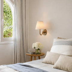 Single-head wall sconce with tapered pleated fabric shade and warm bulb glow, dusty blue shade angled view 3