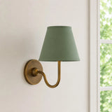 Close view of the pleated fabric shade and diffused warm light on the sconce, red shade lit shot 5