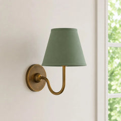 Close view of the pleated fabric shade and diffused warm light on the sconce, red shade lit shot 5