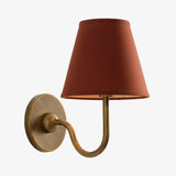 Rustic indoor wall sconce lit to show the warm glow through the linen shade, red shade front view 41